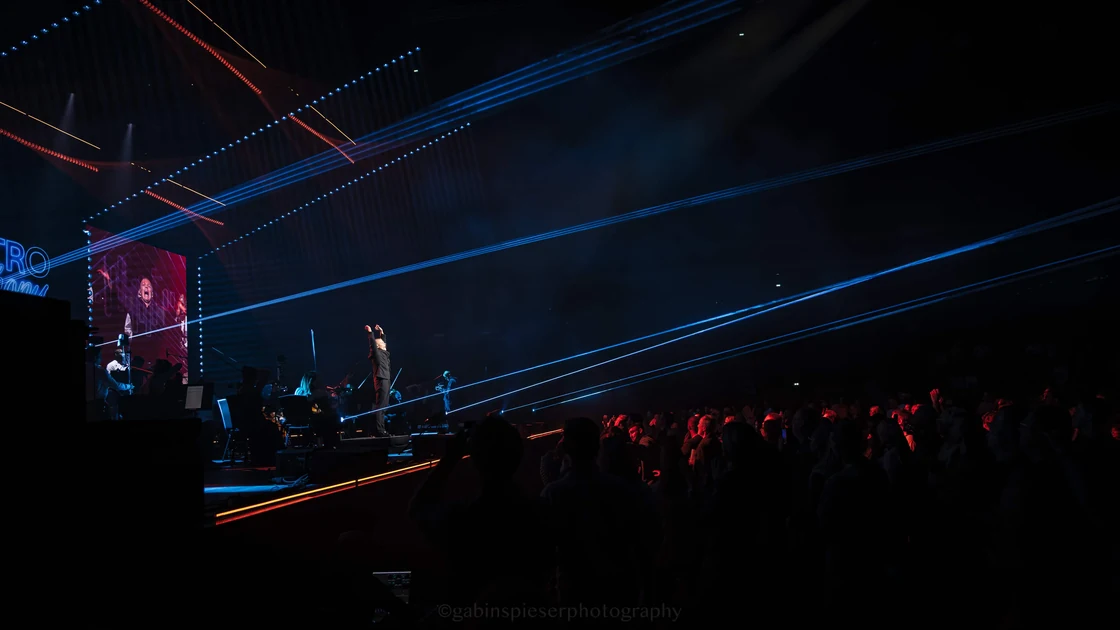 Electro Symphony — Des faisceaux bleus traversent la salle au-dessus de la scène et du public.